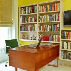 An office with a large desk and bookcases on the walls.